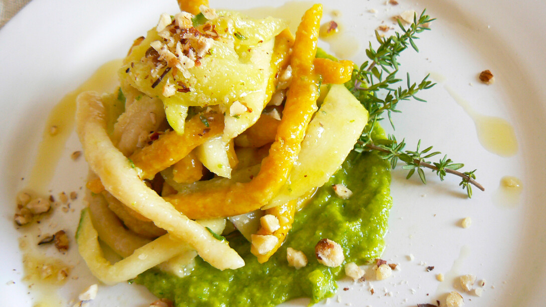Strozzapreti bicolore con curcuma e crema di zucchine speziata con timo fresco e  nocciole tostate  