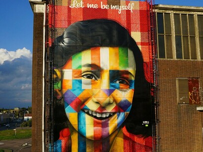 "Let me be myself/Anne Frank", de Eduardo Kobra, em Amsterdã, na Holanda. O mural retrata Anne Frank em uma composição de cores vibrantes e formas geométricas, tendo ao alto a frase que sintetiza a busca pela liberdade de ser. A obra traduz a maneira como Kobra utiliza o espaço urbano para abordar memória, intolerância e paz