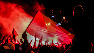 Un hombre alza la bandera de Palestina en una manifestación por el conflicto armado contra Israel