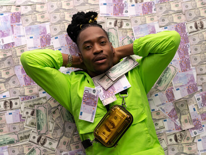 A man with money on his chest, in a container, and behind him