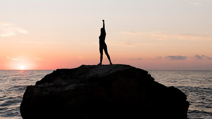 Woman holding her arm up in success, symbolizing learning from mistakes, self-discovery, and personal growth