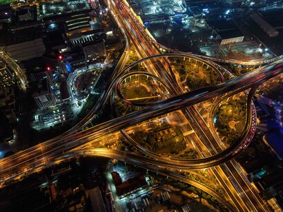 A dense urban network glowing and buzzing with activity at night, representing the scale and complexity of the digital age