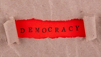 Illustrazione con etichetta "democrazia" scritta in rosso:" Abbiamo già assistito a una perdita dei valori democratici, dei capisaldi costituzionali, del modo di pensare collettivo che partiva dal presupposto di alcune regole di base condivise, fulcro del nostro modo di vivere, che hanno caratterizzato tutto il dopoguerra fino a qualche anno fa"