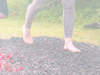 A girl walks quickly on coals for a firewalk