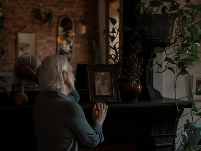 Holding onto a cherished memento, she finds comfort in the familiar touch, a tangible connection that keeps his memory alive in her heart