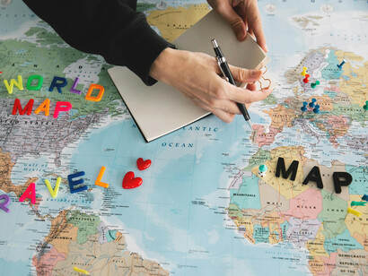 Un hombre hace anotaciones encima de un mapa mundi. Las lenguas habladas en Europa tienen sus raíces en Asia y esto está íntimamente vinculados a las migraciones