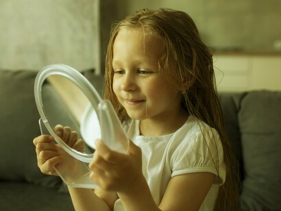 Menina se observa no espelho. Pais que conversam de forma mais elaborada com os pequenos sobre experiências passadas, tendem a desenvolver filhos mais detalhistas em suas conversas