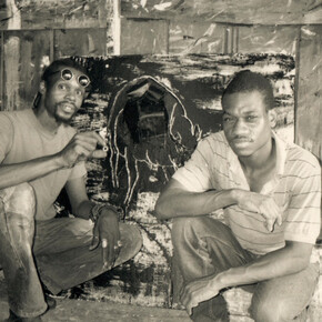 Lonnie Holley and Ronald Lockett in front of Lockett's painting, Instinct for Survival, c. 1992. Artwork: © 2023 Estate of Ronald Lockett/ Artists Rights Society (ARS), New York. 
© Lonnie Holley/ Artists Rights Society (ARS), New York. Courtesy of the artist and Blum & Poe, Los Angeles/New York/Tokyo