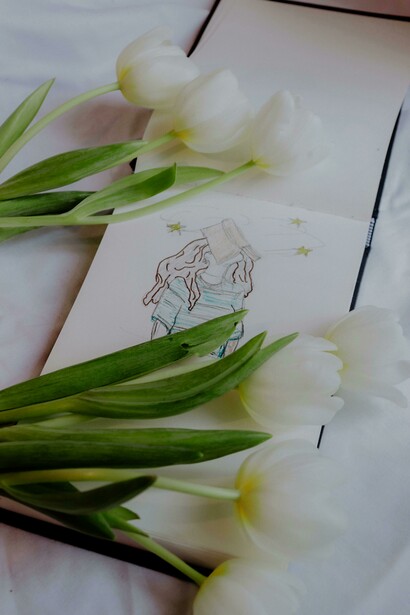 A bouquet of white tulips placed over an anime sketch in Paris, Île-de-France, France