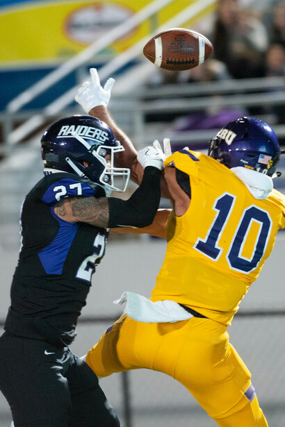An athlete makes a crucial catch in an intense American football match, highlighting speed and skill