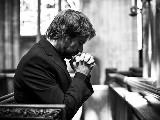 A solitary Christian man praying quietly in a church