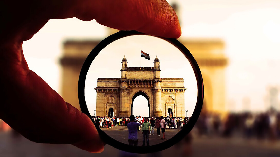 Person holding a round lens in Mumbai, India