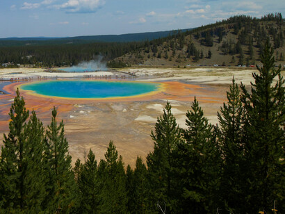 Grand Prismatic Spring surrounded by moutains and pine forests, Yellowstone National Park, USA