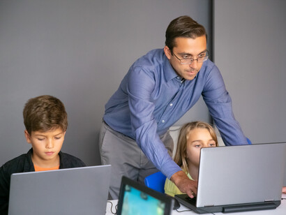 Un insegnante che aiuta una studentessa in un compito al computer