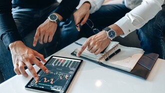 Two people looking at data on a tablet 