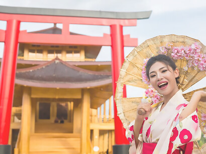 Mesmerizing sight: An elegant Asian woman dressed in a traditional Japanese kimono poses before the iconic Torii gate at the entrance of Tatsuta Shrine, Japan, blending cultural grace with natural beauty