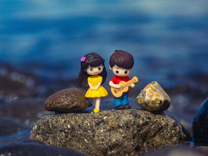 Two figurines standing side by side, symbolising how love bridges differences through compassion and respect