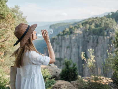 A smiling woman standing on the edge of a canyon during a peaceful nature retreat in the mountains   