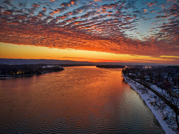An aerial glimpse of Kellogg, Minnesota, painted in crimson and amber during sunset, representing the warmth, nostalgia, and wonder of distant places