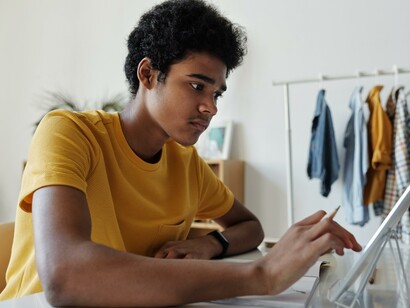A young boy busy studying on his tablet