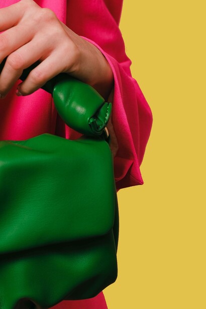 Woman holds a cactus green handbag 