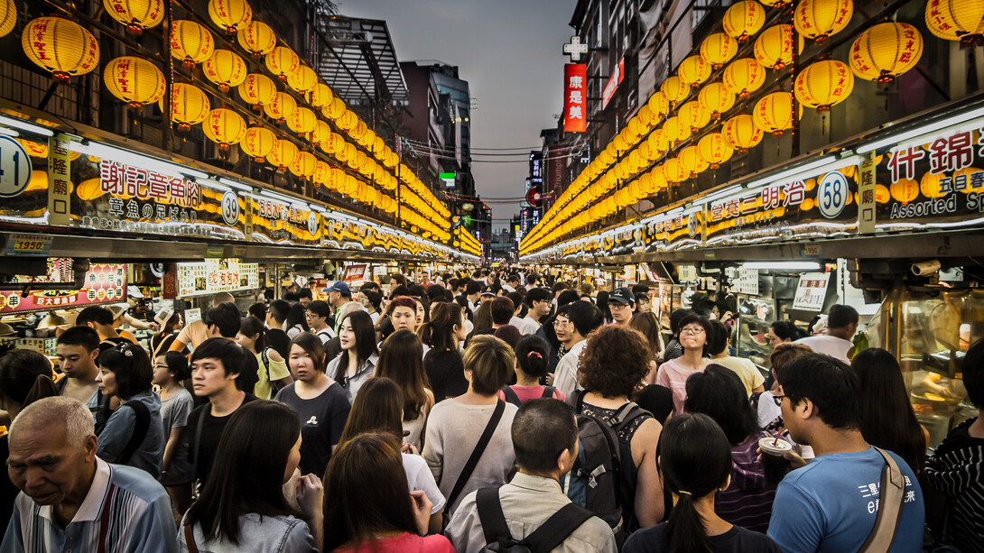 Crowds of tourists exploring the seafood night market in Keelung, Taiwan