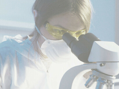 En el laboratorio, una científica se involucra diligentemente con un microscopio, ejemplificando la investigación enfocada y la exploración científica