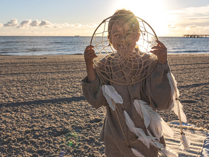 Niña con atrapamilagros y sueños al atardecer en la playa 