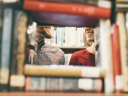 Detalle de dos estudiantes sonriendo entre libros