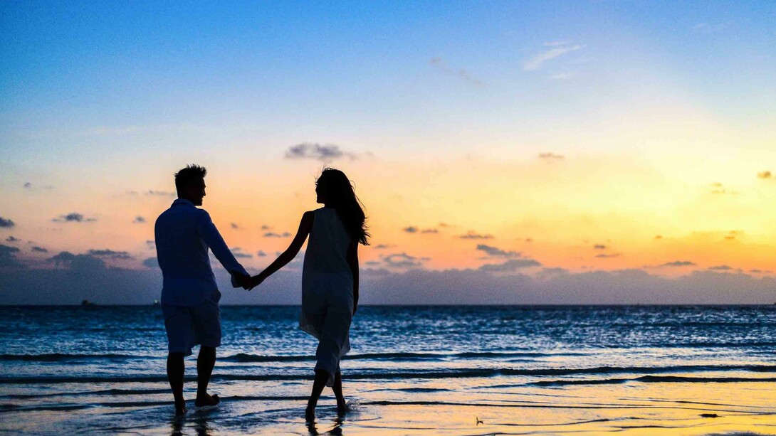 Couple holding hands on the beach