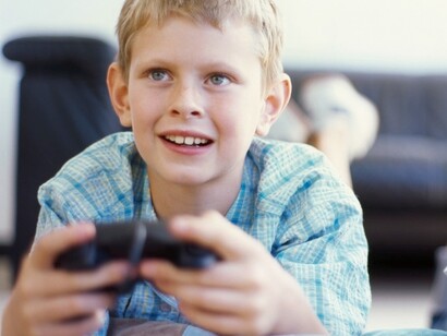 Un niño con la mirada fija en su videojuego