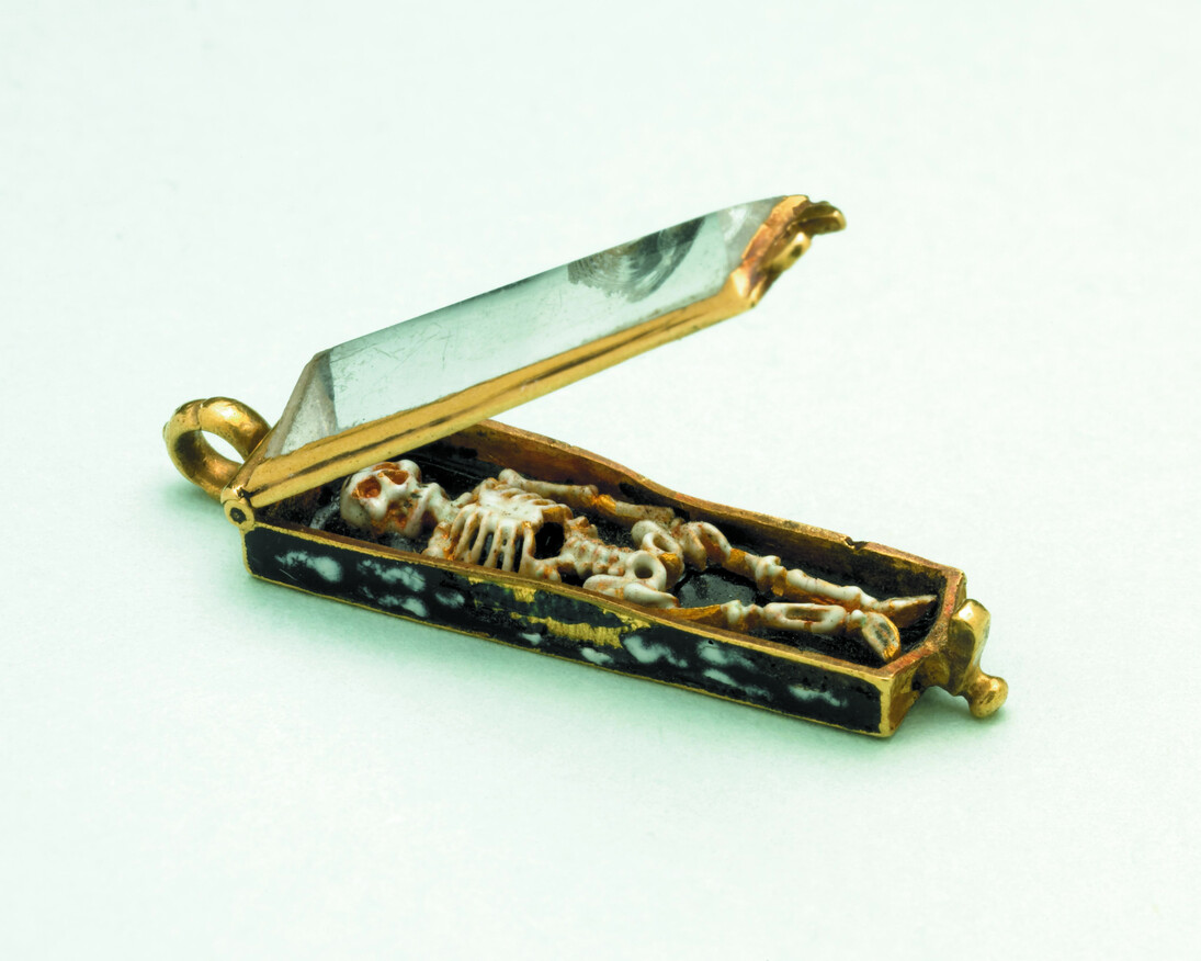 Memento mori pendant France,1500–1600In the late medieval period, reminders that everybody dies helped believers to think of their spiritual rather than worldly wealth. This memento mori pendant contains a tiny skeleton in an enamelled coffin decorated with tongues of fire.© the Trustees of the British Museum