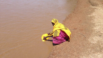 Mujer recolecta agua en África ante la escasez provocada por el cambio climático