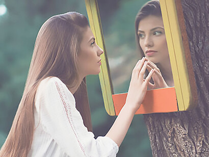 The introspective moment of a young woman as she gazes into a forest mirror, delving into themes of self-reflection and narcissism within a serene natural setting