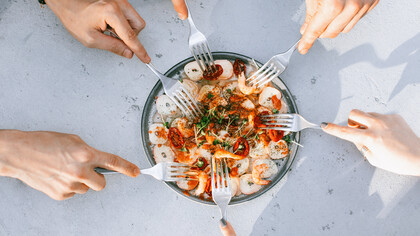 Familiares provam um delicioso prato de comida juntos