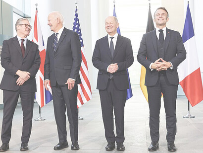 On Friday, October 18, 2024, at the Chancellery in Berlin, Former President Joe Biden engages in conversation with U.K. Prime Minister Keir Starmer, while posing for a family photo with Starmer, German Chancellor Olaf Scholz, and French President Emmanuel Macron during the “European Quad” leaders meeting