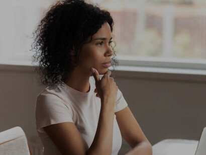 Photo of a young, attractive businesswoman looking stressed while working alone in an office