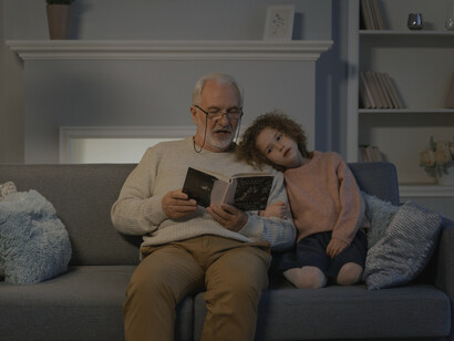 Grandpa reads a story to his granddaughter