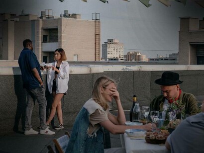 Persone che pranzano insieme sul terrazzo di un palazzo