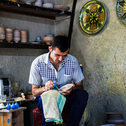 Potter decorating clay products in a workshop in Gijduvon, Bukhara Region, Uzbekistan