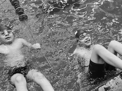Niños tratando de nadar en la piscina