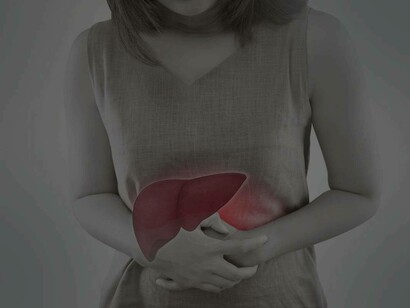 A woman grabbing her abdomen as a result of pain caused by a damaged liver