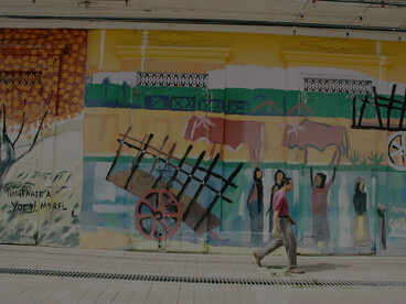 A man walking past a graffiti-covered wall in Santiago de los Caballeros, Dominican Republic