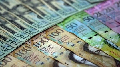 Billetes de bolívares, la moneda nacional de Venezuela, y dólares estadounidenses