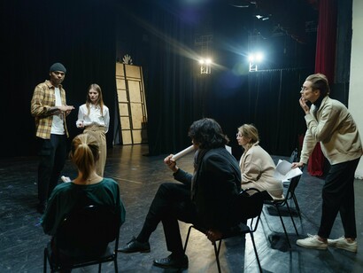 Groupe d'artistes en train de discuter une scénario et faire des répétitions pour la pièce