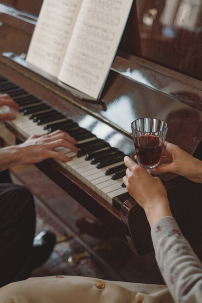 Professora de piano acompanha aluno durante aula