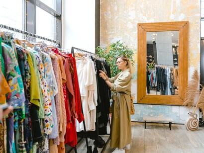 Mulher escolhe roupas em brechó