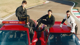 Os pilotos Carlos Sainz e Charles Leclerc vestem terno técnico de lã com fita de gorgorão, suéter de manga longa e botas de couro; Irina Shayk, com terno napa emborrachado, luvas e óculos de couro para a FERRARI, fotografado por Theo Liu. Descubra como a Fórmula 1 se tornou um fenômeno de popularidade e negócios além das corridas, atraindo marcas de luxo e celebridades