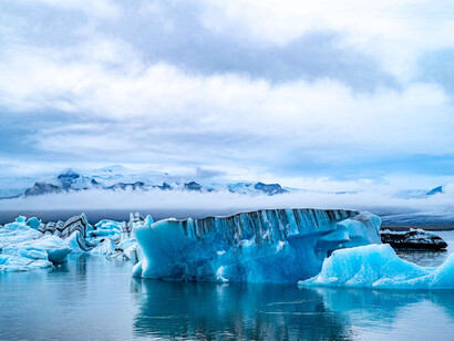 A beautiful blue slab of ice floating in the ocean, emphasizing how choosing environmentally friendly decisions can prevent their disappearance