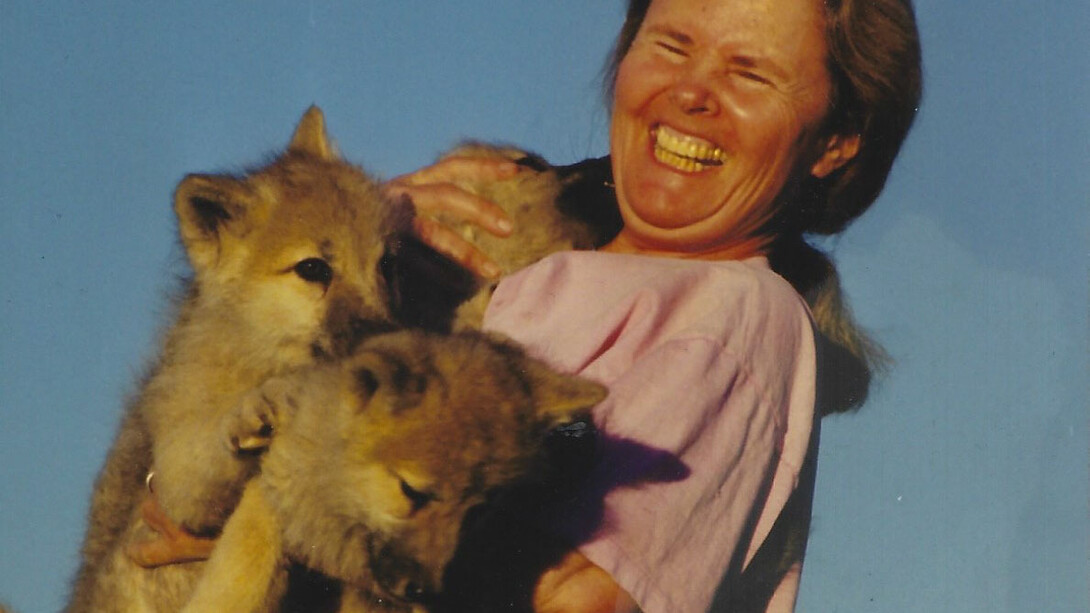 Susan Eirich holding the pups with a wide smile on her face
